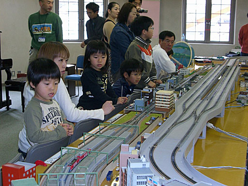 Nゲージレイアウトを走行する列車を見る来場者